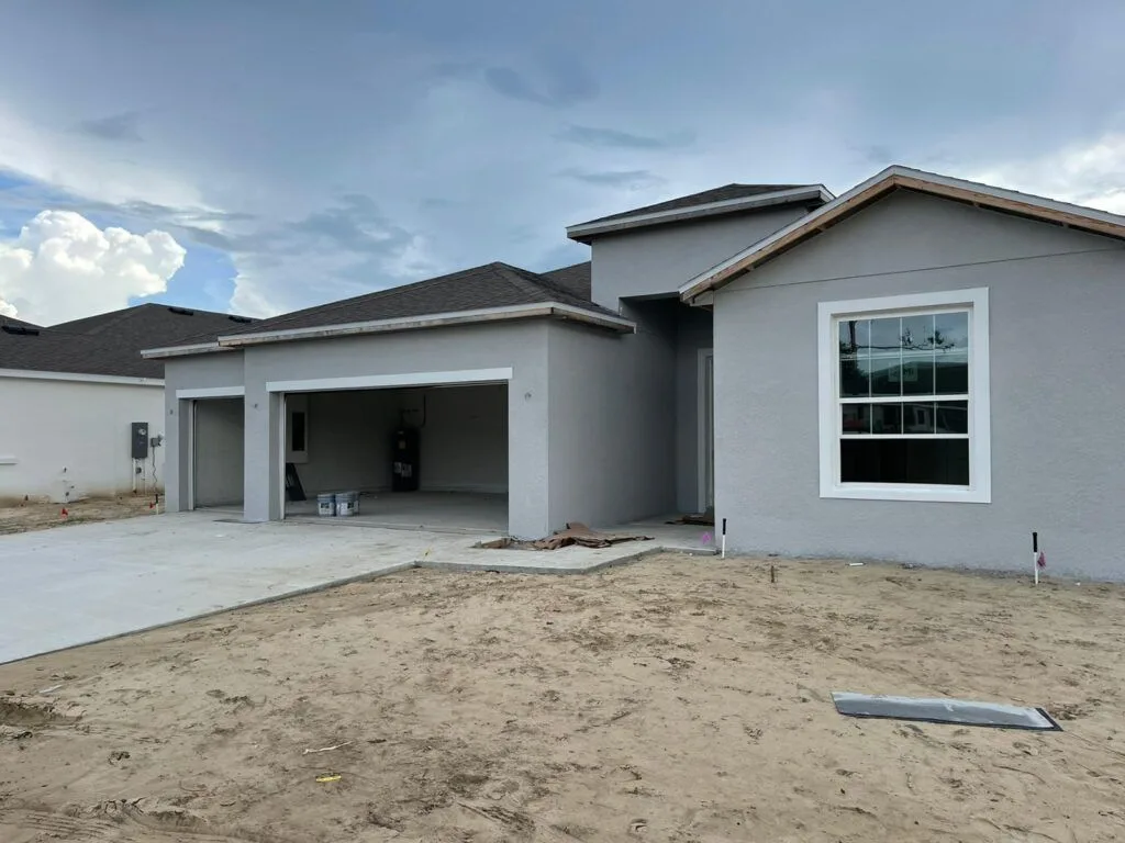 Exterior painters finishing a new construction home in Gainesville, FL