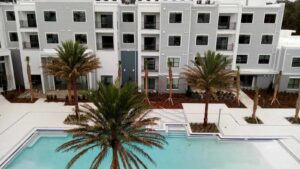 result of commercial building exterior painting by experienced professionals with palm trees and pool