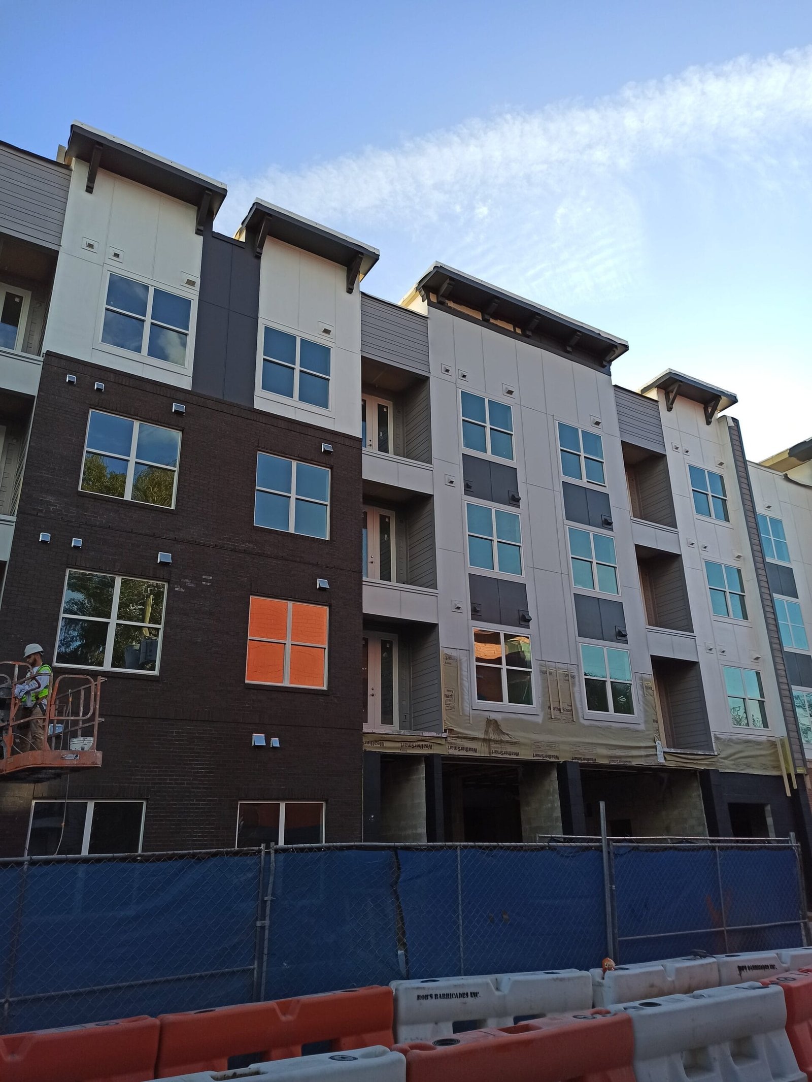 boom lift positioned for safe and efficient access to tall residential building exterior in stadium house