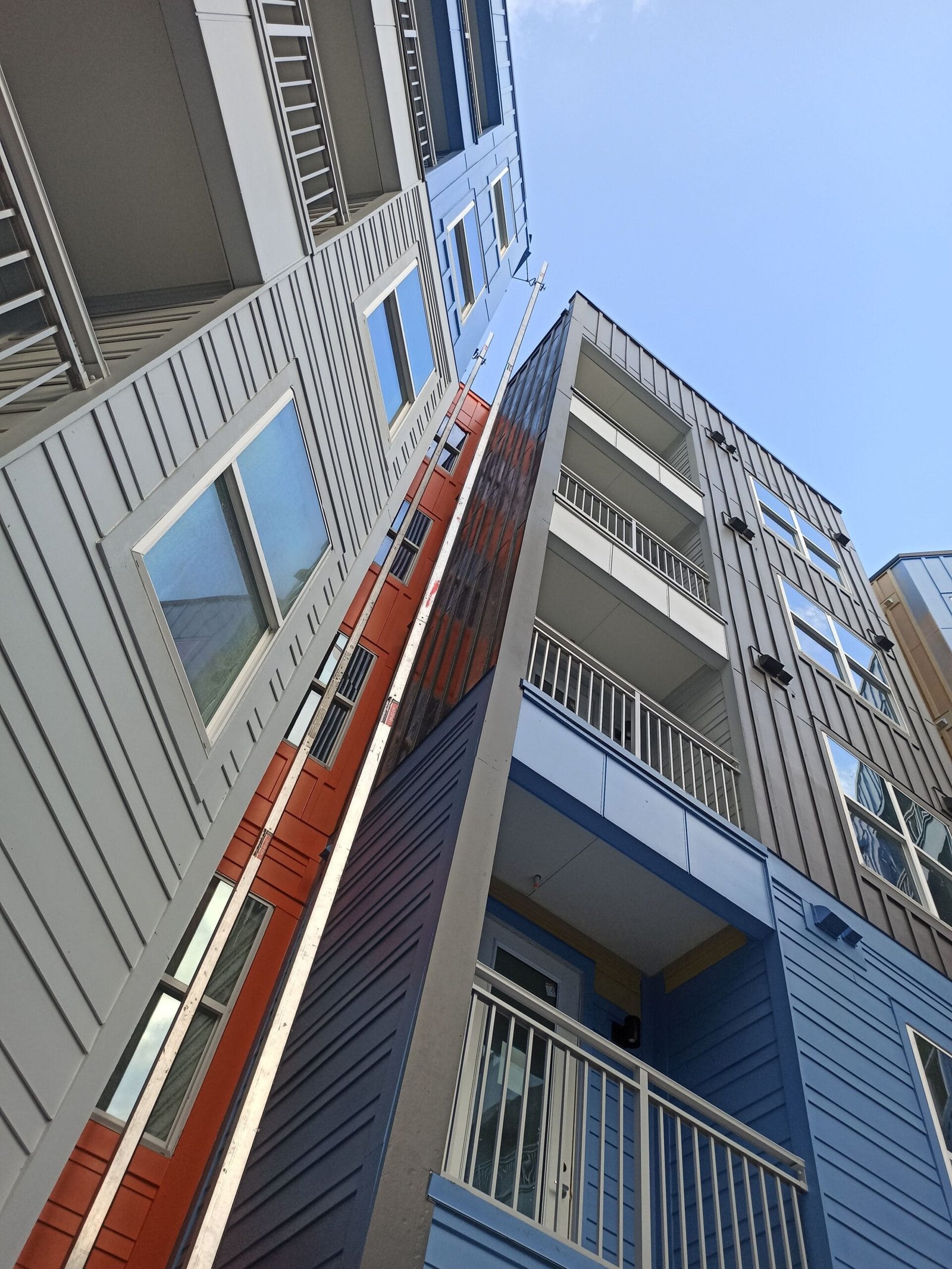 Painting crew working on large commercial building exterior with contrasting colors