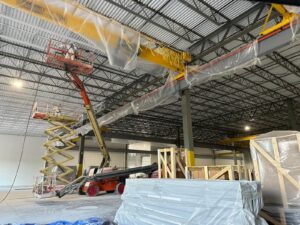 Painters operating a scissor lift and boom lift for a commercial warehouse interior painting project